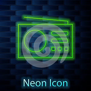 Glowing neon Radio with antenna icon isolated on brick wall background. Vector