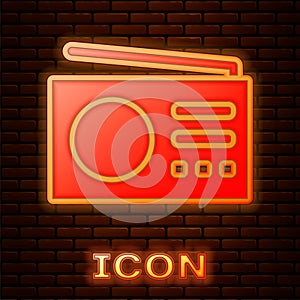 Glowing neon Radio with antenna icon isolated on brick wall background. Vector