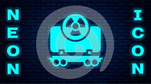 Glowing neon Radioactive cargo train wagon icon isolated on brick wall background. Freight car. Railroad transportation