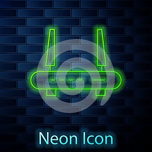 Glowing neon Router and wi-fi signal icon isolated on brick wall background. Wireless ethernet modem router. Computer