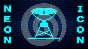 Glowing neon Satellite dish icon isolated on brick wall background. Radio antenna, astronomy and space research. Vector