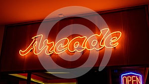 Glowing neon sign with the word "Arcade" illuminated in bright blue and yellow colors