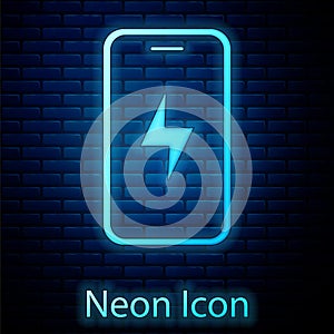 Glowing neon Smartphone charging battery icon isolated on brick wall background. Phone with a low battery charge. Vector