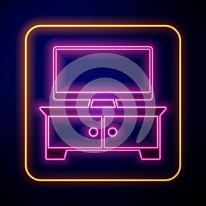 Glowing neon TV table stand icon isolated on black background. Vector