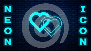 Glowing neon Two Linked Hearts icon isolated on brick wall background. Romantic symbol linked, join, passion and wedding