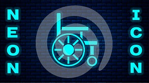 Glowing neon Wheelchair for disabled person icon isolated on brick wall background. Vector