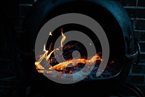 Glowing orange burning embers in a chiminea fire