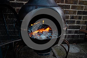 Glowing orange burning embers in a chiminea fire