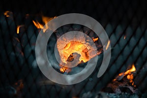 Glowing orange burning embers in a chiminea fire