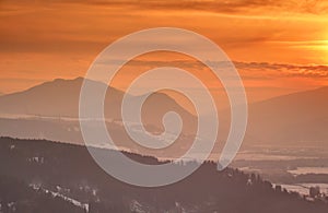 Glowing orange sunlight over silhouettes of Velka Fatra peaks