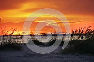 The glowing orange sunset over the bridge that leads to Sanibel and Captiva islands from Ft.Myers Beach, Florida.