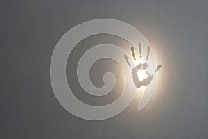 Glowing palm print on the wall. Space for text.