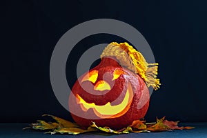 Glowing pumpkin with autumn leaves on a dark background. Jack`s Lantern. Halloween Decorations