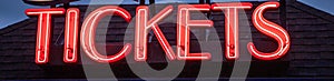 Glowing red neon tickets sign