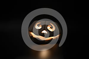 Glowing smiling face Halloween pumpkin, candle holder, isolated on night dark black background.