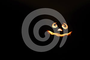 glowing smiling face Halloween pumpkin, candle holder, isolated on night dark black background. space for text.