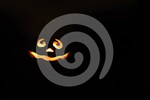 Glowing smiling face Halloween pumpkin, candle holder, isolated on night dark black background. space for text.