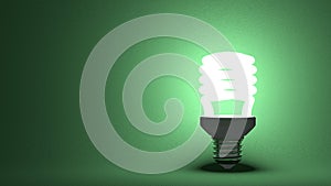 Glowing spiral light bulb on green