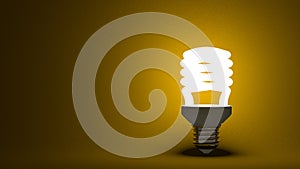 Glowing spiral light bulb on yellow