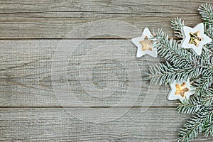 Glowing star garland lights with christmas tree branch on gray wooden background