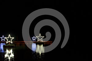 Glowing stars on water with reflection, black