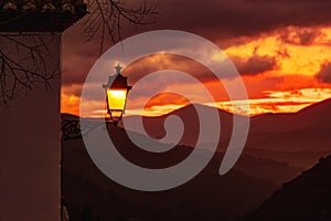 Glowing street lamp on mediterranean sunset