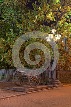 Glowing street light and cannon at night