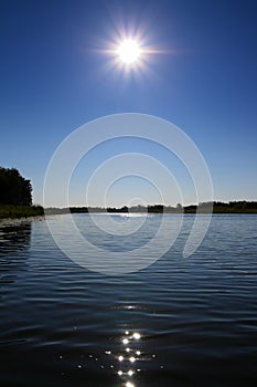 Glowing sun over lake