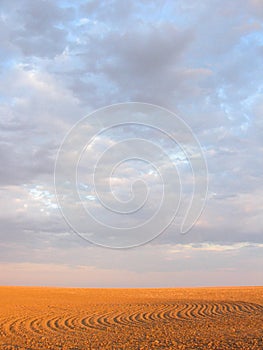 Glowing tilled patterned field under pink and blue sky photo