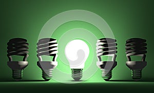 Glowing tungsten Light bulb among dead spiral ones