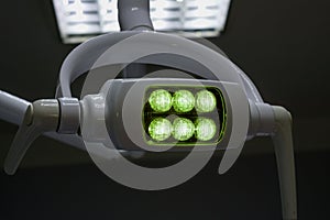 Glowing white medical shadowless lamp with green light photo