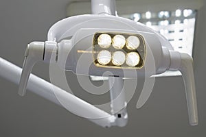 Glowing white medical shadowless lamp with yellow light photo