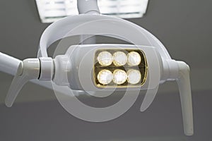 Glowing white medical shadowless lamp with yellow light photo