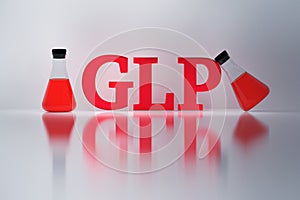 GLP red letters and laboratory flasks reflected on the white surface.