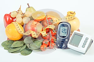 Glucometer, blood pressure monitor, fruits with vegetables and centimeter, healthy lifestyle