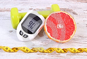 Glucometer for checking sugar level, grapefruit and dumbbells for fitness, diabetes, healthy lifestyles