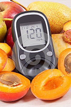 Glucometer and fresh natural fruits containing vitamins for healthy lifestyles of diabetics