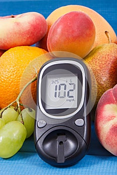 Glucometer and fresh natural fruits containing vitamins for healthy lifestyles of diabetics