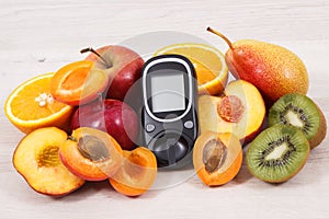 Glucometer and fresh natural fruits containing vitamins for healthy lifestyles of diabetics