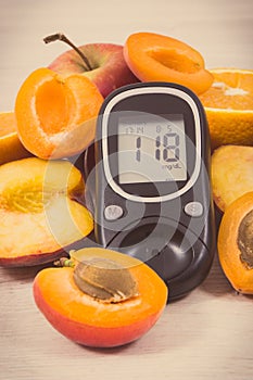Glucometer and fresh natural fruits containing vitamins for healthy lifestyles of diabetics. Vintage photo