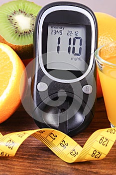 Glucometer, fruits, juice and tape measure, diabetes lifestyles and nutrition