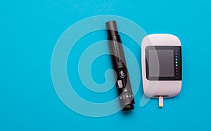 glucometer and lancing device on a blue background photo