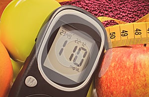 Glucometer with result of sugar level, fresh fruits and dumbbells using in fitness. Healthy nutrition and sporty lifestyles