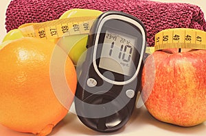 Glucometer with result of sugar level, fresh fruits and dumbbells using in fitness. Healthy nutrition and sporty lifestyles