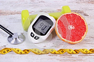 Glucometer, stethoscope, fresh grapefruit and dumbbells for fitness, diabetes, healthy lifestyles