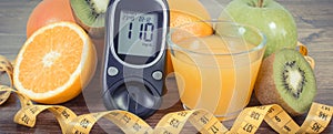 Glucometer with sugar level, fresh fruits and orange juice. Source natural minerals and vitamins