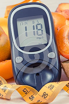 Glucometer, tape measure and fresh natural fruits containing vitamins for healthy lifestyles of diabetics