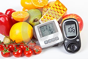 Glucose meter, blood pressure monitor, fruits with vegetables and medical pills