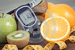 Glucose meter for checking sugar level, fresh fruits and orange juice. Healthy lifestyle and nutrition during diabetes