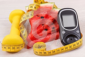 Glucose meter for checking sugar level, portion of watermelon, centimeter and dumbbells, diabetes and healthy lifestyles concept